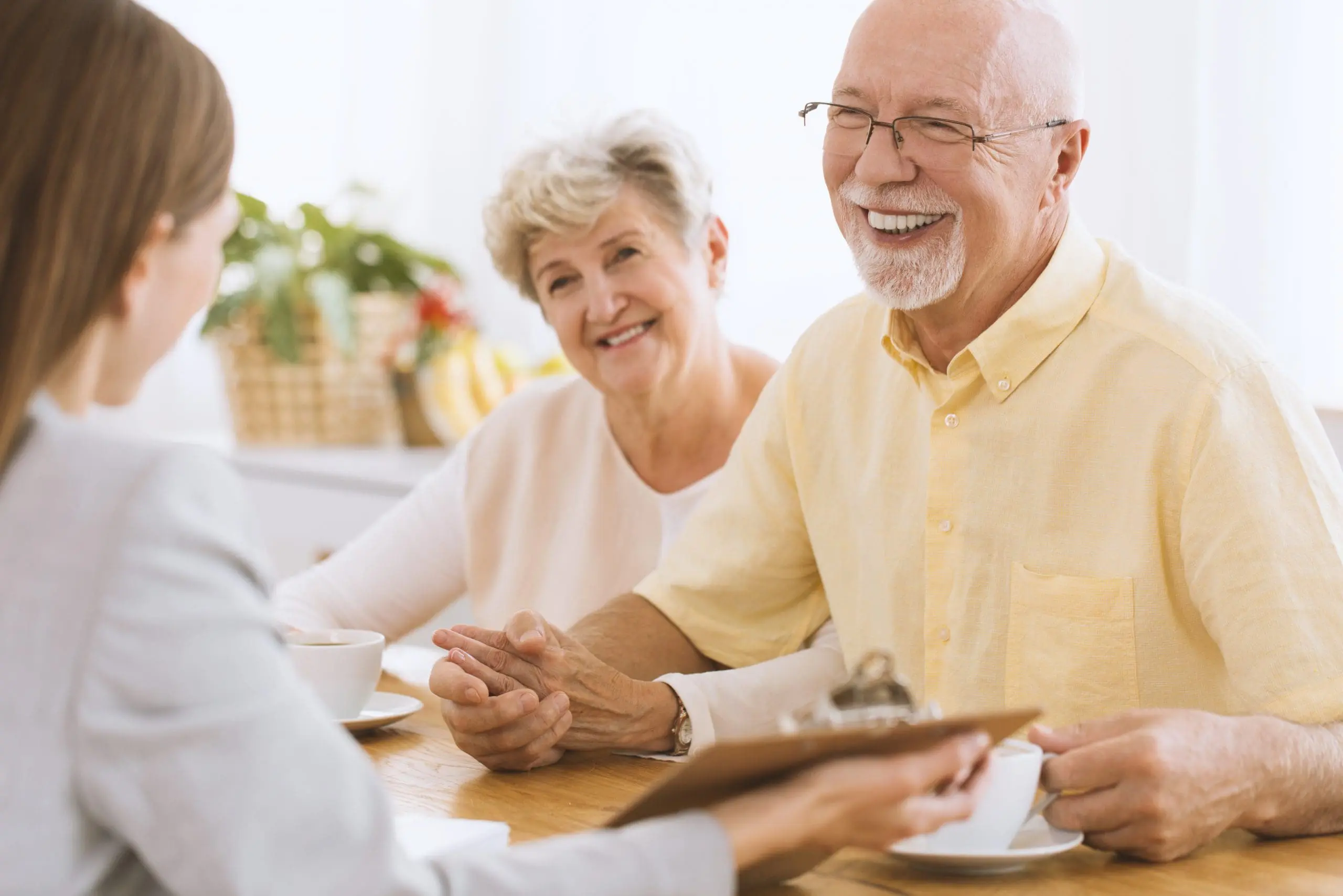 Mature couple smiling during a meeting with their financial advisor.