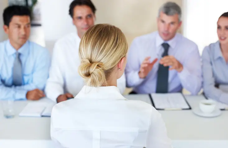A young woman being interviewed by four businesspeople. Establishing a line of succession ensures you keep homegrown talent in-house.