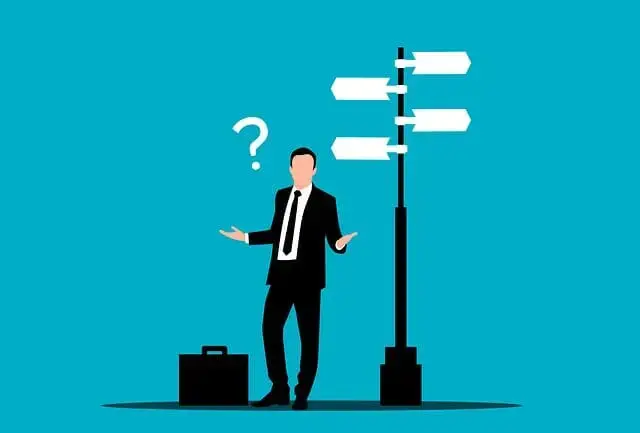 A businessman standing quizzically at a crossroads. The sudden change one faces at retirement can make decisions difficult.